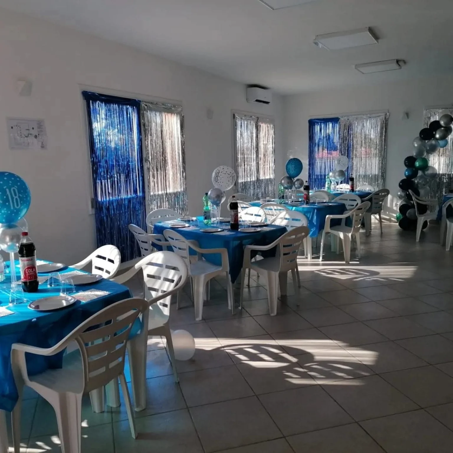 Sala allestita con tovaglie blu e decorazioni