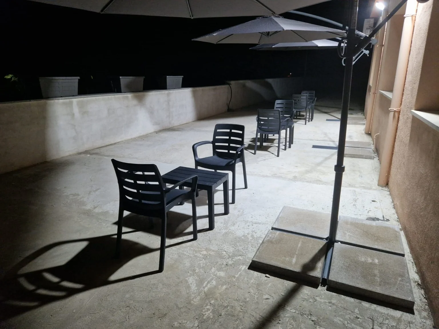 Terrazza con tavolini, sedie e ombrelloni